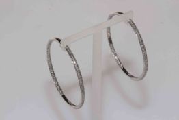 Large 14 carat white gold diamond inside out set hoop earrings.