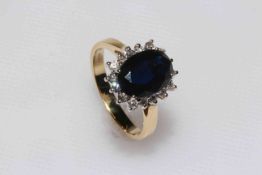 Sapphire and diamond cluster 18 carat gold ring, having 3.3 carat oval sapphire, size M.