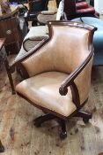 Mahogany framed and light brown leather swivel armchair.