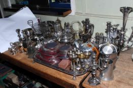 Collection of silver plated wares including teapots, cutlery, candelabra, serving tray.