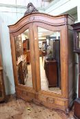 Oak arched top armoire having two mirror panelled doors above two drawers,