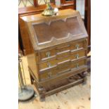 Early 20th Century oak three drawer bureau, the fall front drawing fitted interior,