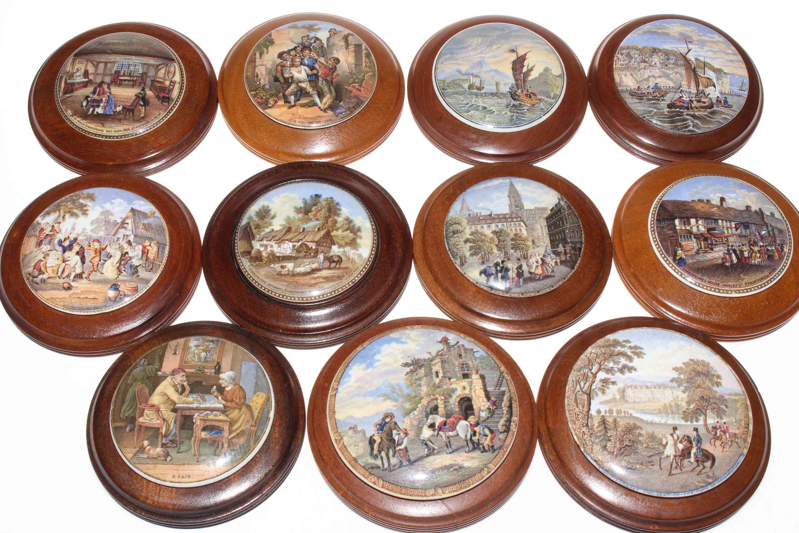 Eleven Pratt Ware pot lids with mahogany mounts including Pegwell, a pair,