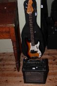 Electric guitar marked Fender Precision Bass with cube 15 amp.