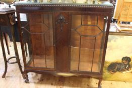 Mahogany two door china cabinet raised on ball and claw feet.
