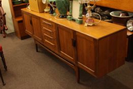 Teak sideboard having four central drawers flanked either side with double cupboard doors.