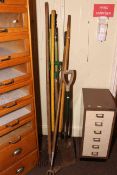 Collection of gardening hand tools including rakes, fork, spade, etc.