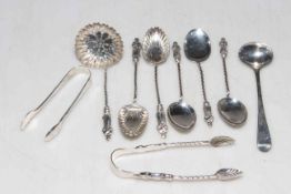 Collection of silver spoons, tongs and sifter.