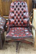 Red deep buttoned leather swivel office armchair.