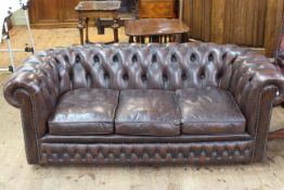 Brown deep buttoned leather three seater Chesterfield settee.