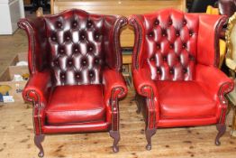 Pair red leather button backed wing armchairs.