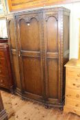1920's carved oak shaped front hall wardrobe, 184cm by 119cm by 47cm.