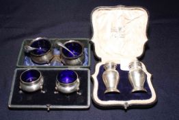 Cased pair of silver pepperettes, London 1915, and two pair of silver open salts, one boxed.