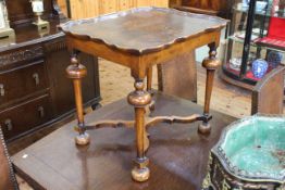 Walnut shaped dished top lamp table raised on turned legs joined by shaped stretchers,
