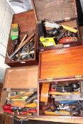 Four small boxes of tools including spoke shaves, planes, measures, gauges, etc.