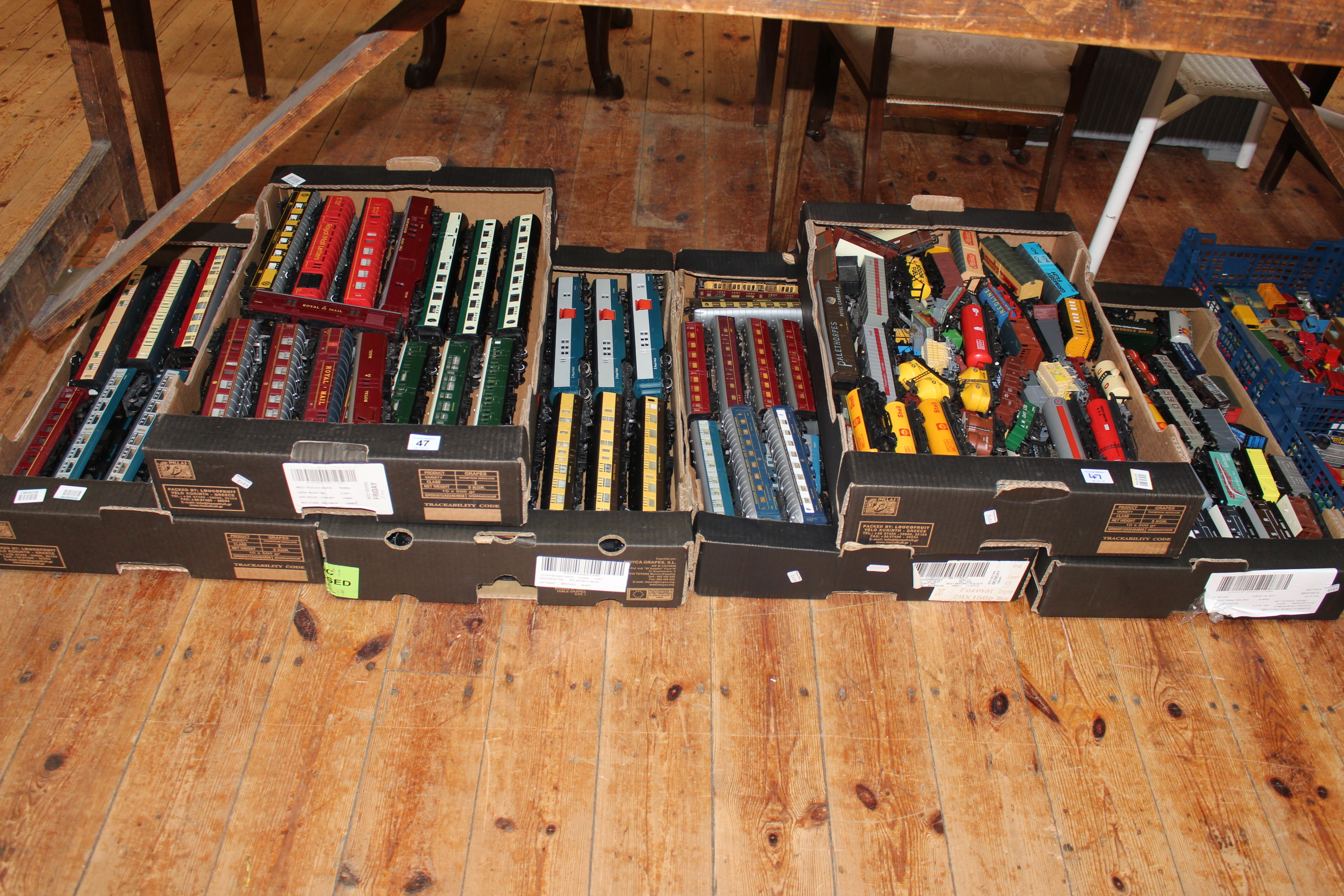 Six boxes of model railway carriages and freight wagons.