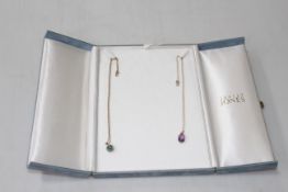 Two 9 carat gold, emerald and amethyst pendants and chains.