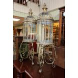 Pair of gilt metal and glazed hall lanterns on ornate stands, 109cm high.