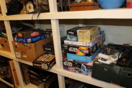Full shelf of games and books including Star Wars, guitar, marbles, etc.