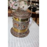 Heavy brass and copper biscuit jar with relief stag and wildlife decoration, 20cm.