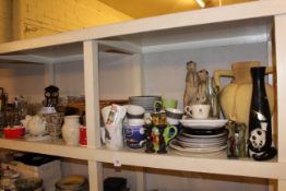 Full shelf including picnic hamper, pictures, brassware, crockery, glassware, Meerkat figures, etc.