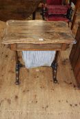 Victorian rosewood sewing table of serpentine form having fitted frieze drawer above a deep drawer,