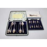 Two cased sets of silver teaspoons and coffee spoons (one spoon short), and silver replica spoon.