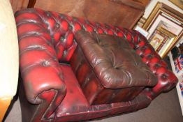 Ox blood deep buttoned leather two seater Chesterfield settee and footstool.