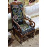 Victorian mahogany scroll arm rocking chair in floral needlework.