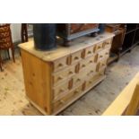 Pine thirteen drawer chest on turned feet, 86cm by 130cm by 50cm.