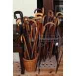 Collection of vintage walking sticks in a stick stand and basket.