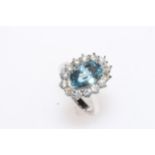 18 carat white gold, blue topaz and diamond cluster ring, having 8 carat oval blue topaz, size N.