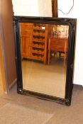 Rectangular black swept frame bevelled wall mirror, 106cm by 75cm.