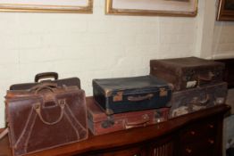 Four vintage suitcases and three leather briefcases.