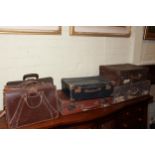 Four vintage suitcases and three leather briefcases.