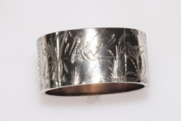 Silver hinged bangle with engraved decoration of birds, butterfly and water plants, 31mm wide.