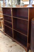 Late 19th/early 20th Century mahogany two division open bookcase on shaped bracket feet having six
