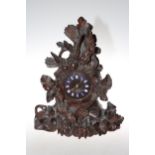 Black Forest carved mantel clock decorated with birds and foliage, 43cm high.