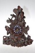 Black Forest carved mantel clock decorated with birds and foliage, 43cm high.