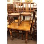 Oak draw leaf dining table and four chairs.
