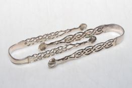 Two pair of silver sugar tongs with fretwork arms and shell design bowls.