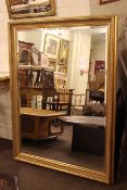 Rectangular gilt framed bevelled wall mirror 136cm by 105cm overall.