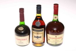 Two bottles of Courvoisier Cognac and a bottle of Martell Cognac.