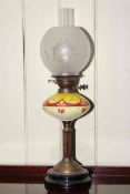 Brass column oil lamp with decorated yellow glass reservoir and frosted and etched glass shade.