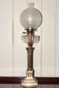 Brass corinthian column oil lamp with clear glass reservoir and frosted and etched glass shade.