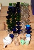 Quantity of various eye baths in green, Bristol blue and clear glass.