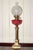 Brass corinthian column oil lamp with ruby glass reservoir and etched glass shade.