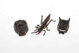 Japanese bronze grasshopper, signed, 11cm long, and two bronze mask fasteners (3).