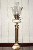 Brass corinthian column oil lamp with clear glass reservoir and shade.