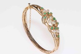Emerald and pearl 9 carat gold hinged bangle, with fancy foliate setting and three sides pierced.